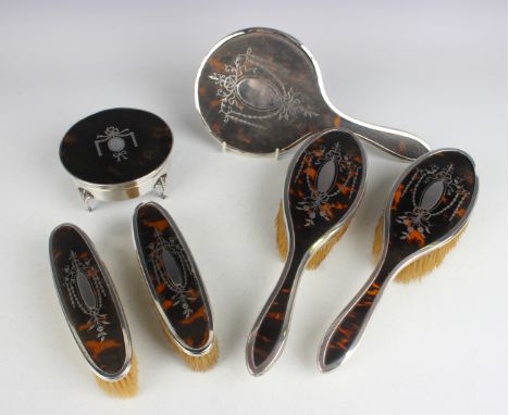 A George V silver and tortoiseshell mounted circular trinket box, the hinged lid piqué inlaid with a ribbon and pendant garla