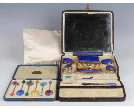 An Art Deco silver gilt and blue enamelled part manicure set, comprising comb, brush, pair of rouge pots, two cut glass pots,