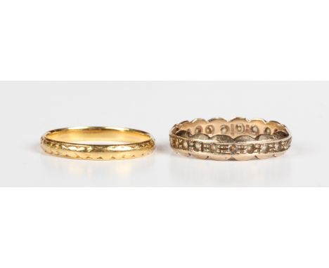 A 22ct gold decorated wedding ring, weight 2.1g, ring size approx M1/2, and a 9ct gold and colourless gem set eternity ring, 