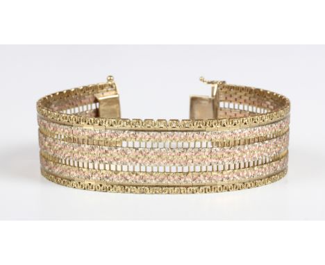 A 9ct three colour gold bracelet in a wide pierced link design with a textured finish, weight 45.9g, length19.2cm, with a cas