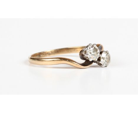 A gold and diamond two stone ring, claw set with cushion cut diamonds in a crossover design, unmarked, weight 2.7g, ring size