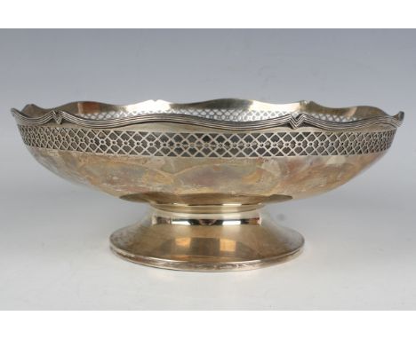 A George V silver circular bowl, pierced with a lattice band beneath a wavy reeded rim, raised on a circular foot, Birmingham