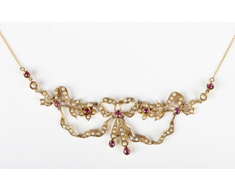 An Edwardian gold, ruby and half-pearl set necklace, the front with a central bow motif between floral and foliate sides, on 