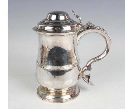 A George III silver tankard, the girdled baluster body with domed hinged lid and scroll handle, on a stepped circular foot, t