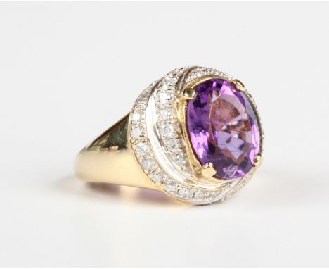 An 18ct gold ring, claw set with an oval cut amethyst within a swirling surround of circular cut diamonds, weight 8.4g, ring 