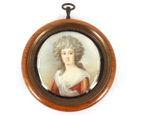 A pair of portrait miniatures, depicting young ladies, one with lace collar and jewels, contained in circular fruitwood and b