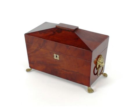 A 19th Century mahogany sarcophagus shaped three section tea caddy, flanked by lion mask ring handles and raised on paw feet,