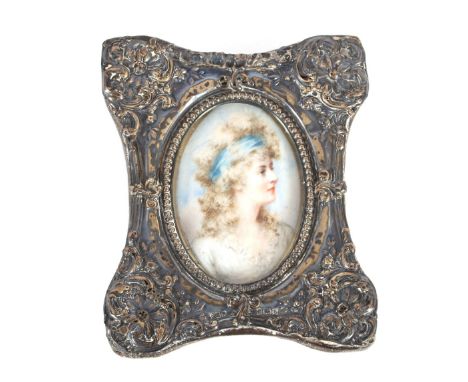 19th Century school, oval miniature portrait of a young woman with lace dress and blue ribbon in her hair, contained in a fol