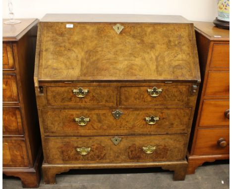 An 18th Century walnut bureau, the fall front opening to reveal an interior arrangement of drawers and pigeon-holes around a 