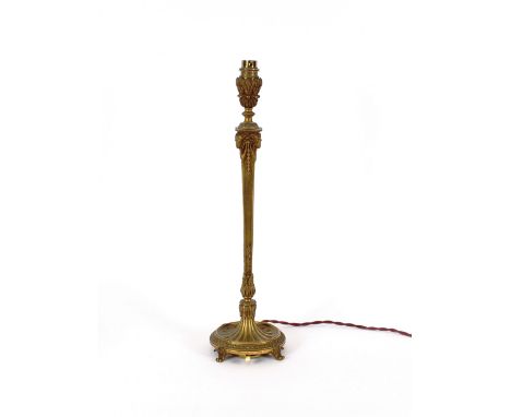 An early 20th Century gilt metal table lamp, having leaf and ram's head mask decoration, raised on a circular base and scroll