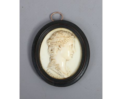 An early C19th continental carved ivory portrait miniature of a young maiden titled Lepida and in ebonized moulded oval frame