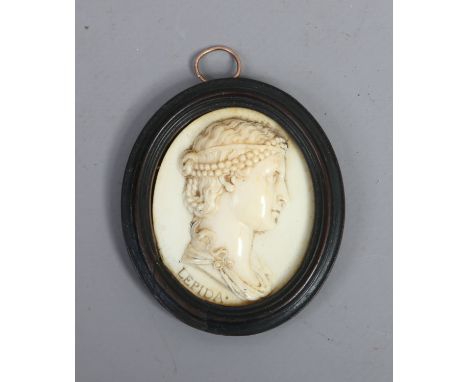 An early C19th continental carved ivory portrait miniature of a young maiden titled Lepida and in ebonized moulded oval frame