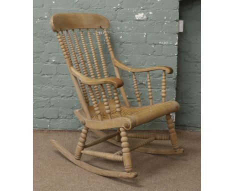 A Victorian walnut bobbin turned rocking chair with bergere seat.