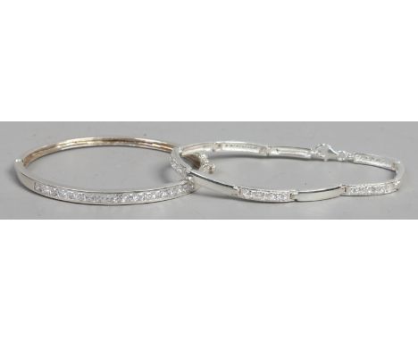 A silver bangle and similar bracelet each set with cubic zirconia stones