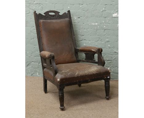 A Victorian carved mahogany armchair with upholstered back rest and seat, raised on turned supports.