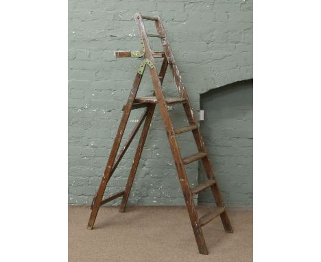 A pair of folding wooden step ladders.