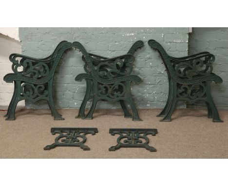 Six painted cast iron garden bench ends along with two coffee table ends.