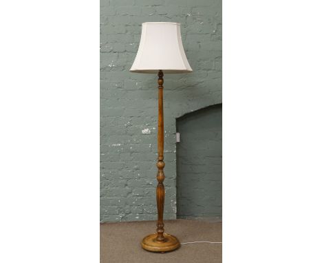 A turned wooden standard lamp.