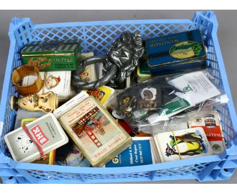 A box of collectables to include vintage playing cards, advertising tins, enamel badges etc.