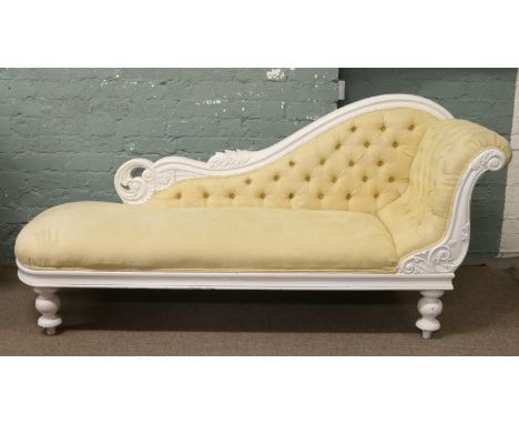 A Victorian style painted chaise longue with deep button upholstery.