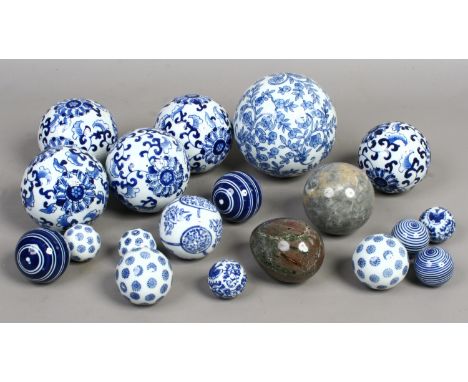 A box of blue and white ceramic decorative balls along with a marble egg.
