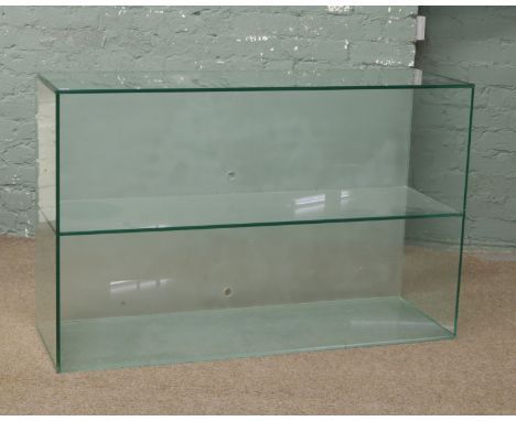 A glass display stand with single shelf.