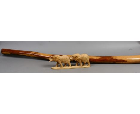 An African wood carving of two elephants along with a didgeridoo