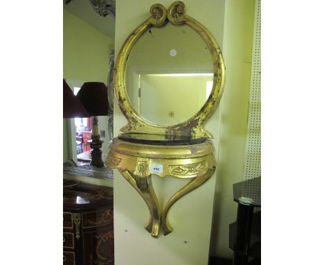 A CONTINENTAL GILTWOOD WALL BRACKET surmounted with an oval mirror within a C scroll frame the black vein marble shelf above 