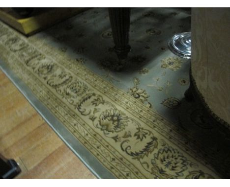 A WOOL RUG the light blue and brown ground with central floral panel within a conforming border 288cm x 203cm