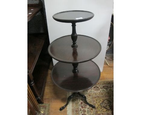 A GEORGIAN STYLE MAHOGANY THREE TIER DUMB WAITER c.1900 of circular dish outline each moulded shelf joined by a baluster supp