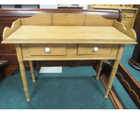 A PINE SIDE TABLE the rectangular top with moulded gallery above two frieze drawers on turned legs 92cm (h) x 113cm (w) x 49c