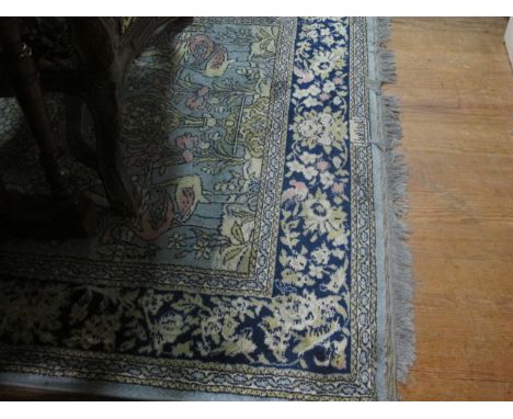 A WOOL RUG the light blue ground decorated with flowerheads, foliage and flamingos within a foliate and flowerhead border 185