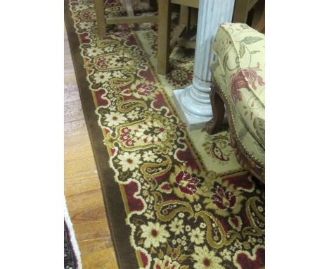 A WOOL RUG the light brown and beige ground with central floral panel within a conforming border 350cm x 250cm