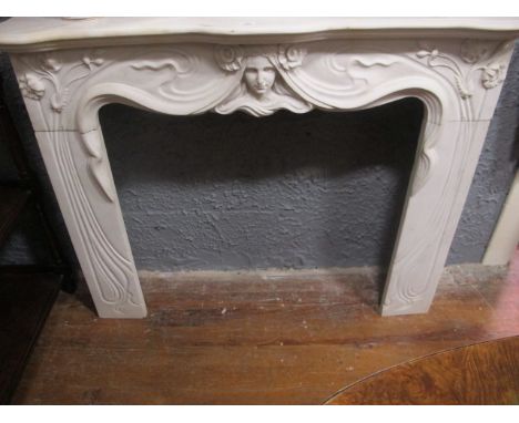 AN ART DECO STYLE WHITE MARBLE CHIMNEY PIECE the serpentine moulded shelf above a figural carved frieze raised on carved flow