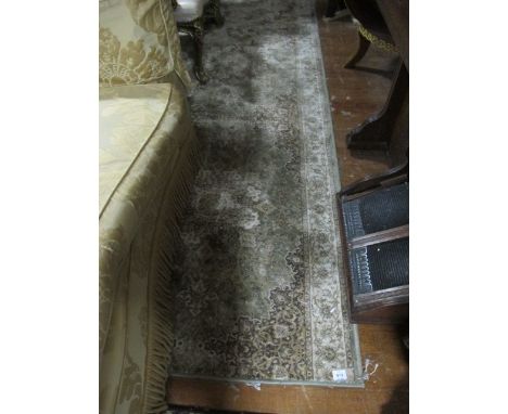 A WOOL RUNNER the light green and beige ground with central floral panel within a conforming border 426cm x 98cm