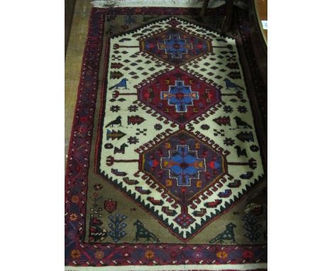 A WOOL RUG the light blue, wine and beige ground with central panels containing palmets within a conforming border 150cm x 10