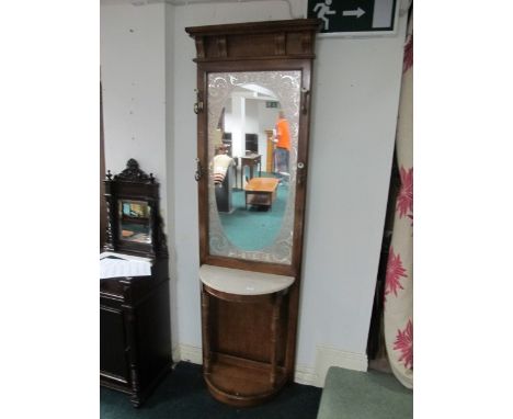 A WALNUT HALL STAND the rectangular mirror with moulded frame with brass and porcelain hooks above a demi-lune marble top on 