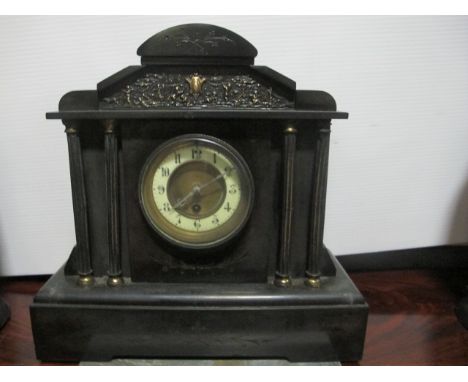A BLACK SLATE MANTLE CLOCK of architectural form the rectangular arched case with brass dial between fluted columns on platfo