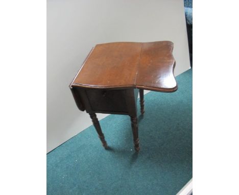 A WALNUT DROP LEAF TABLE of serpentine outline the shaped moulded top above a hinged cupboard raised on fluted and ring turne