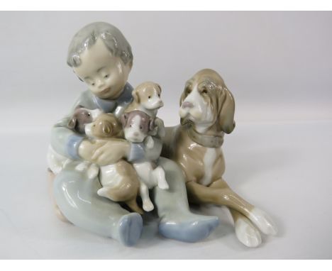 Lladro figurine "New playmates" featuring a boy with a dog and puppies, 4 3/4" tall.