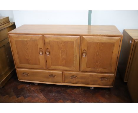 Ercol Sideboard mounted on castors. Three cupboard doors above two lower drawers. H:30 x W:51 x D:17 inches. See photos.