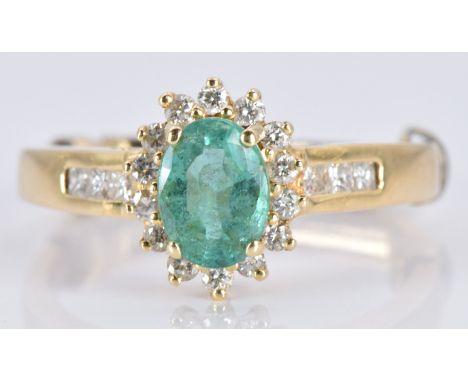 An 18k gold ring set with an oval emerald and diamonds, 3.6g, size K