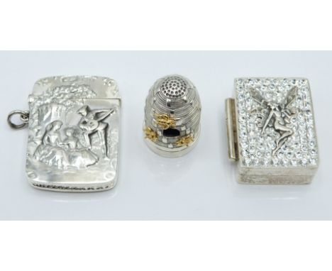 White metal vesta case with embossed decoration of a man playing the lute to two ladies, height 4.5cm together with a trinket