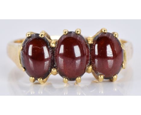 An 18ct gold ring set with three garnet cabochons, 3.6g, size M&nbsp;