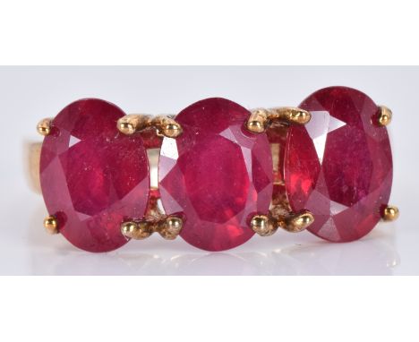 A 9ct gold ring set with three oval rubies, 3.7g, size J