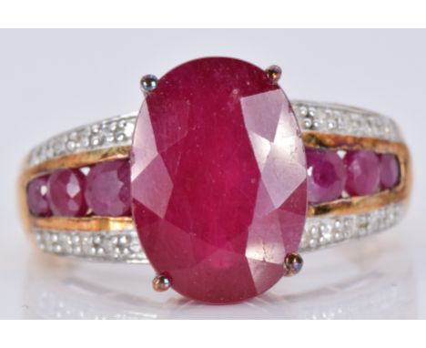 A 9ct gold ring set with a large oval ruby and diamonds, with three round cut rubies to each shoulder, 6.0g, size S