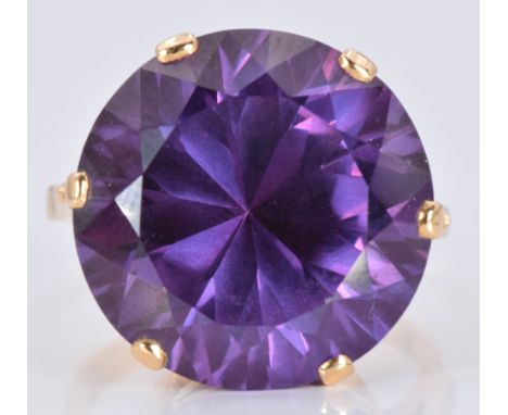 A yellow metal ring set with a large round cut synthetic sapphire, 15.7g, size U