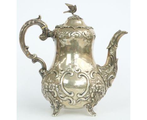 Victorian hallmarked silver teapot with bulbous body and embossed decoration, raised on four feet and with bird finial or han