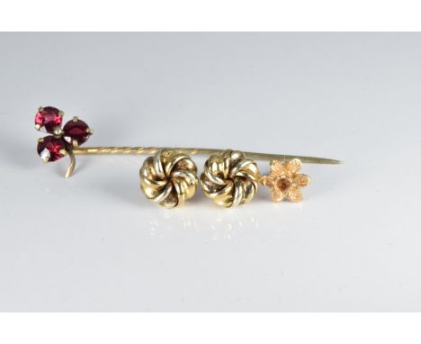 A pair of yellow metal knot earrings, a yellow metal earring (1.6g) and a Victorian stick pin set with garnets&nbsp;