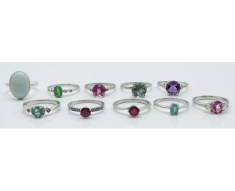 Ten silver rings set with ruby, blue opal, pink topaz, green fluorite, ruby, emerald, amethyst, opal all with certificates